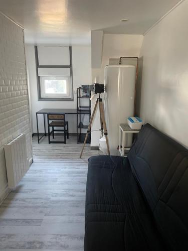 - un salon avec un canapé et un réfrigérateur dans l'établissement Proche plage port commerces et gare à 2h de Paris, à Fécamp
