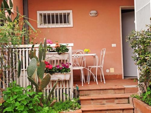 a porch with a table and chairs and flowers at Acasuzzadiaci in Aci Castello