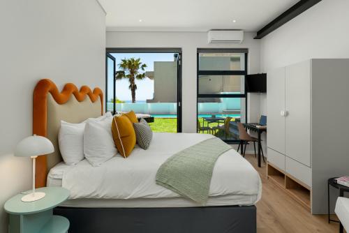 a bedroom with a bed and a living room at Neighbourgood 1st Crescent Camps Bay in Cape Town