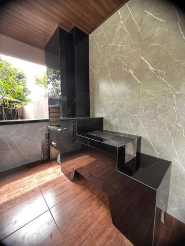 La salle de bains est pourvue d'un comptoir noir et d'un mur en marbre. dans l'établissement Villaggio das Árvores, à Retiro