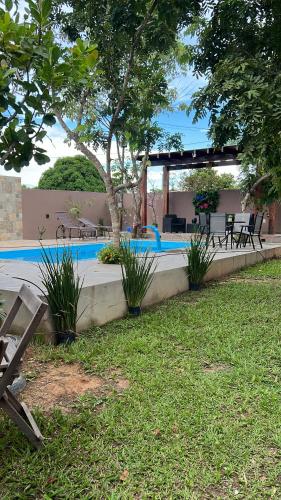 - une piscine avec une table et des chaises dans la cour dans l'établissement Villaggio das Árvores, à Retiro