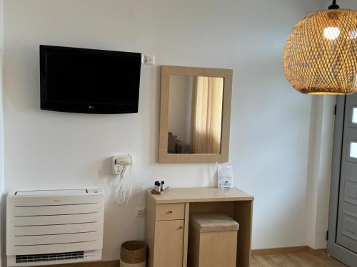 a room with a television and a table with a mirror at Dimitri Hotel in Himare