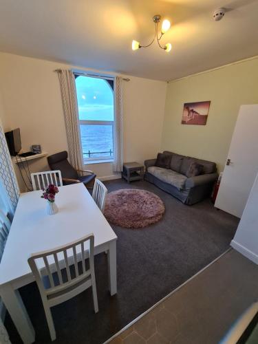 a living room with a white table and chairs at Farina No6, Sea view apartment sleeping 4 guests in Bridlington