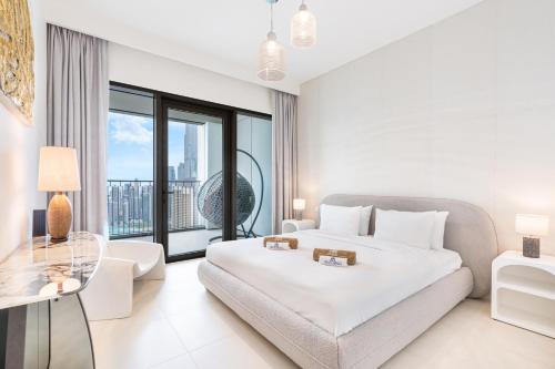 ドバイにあるPremium Home on 45th Floor with Full Burj Viewの白いベッドルーム(ベッド1台、ガラスのテーブル付)