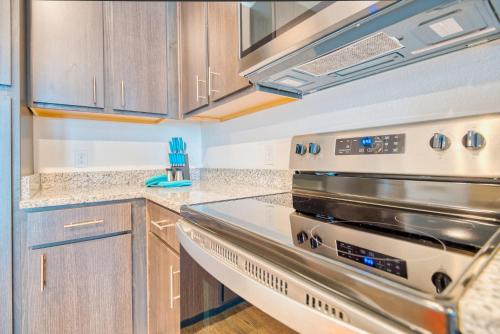 a kitchen with stainless steel appliances and wooden cabinets at Luxe One Bedroom Apartment with Balcony in Gainesville
