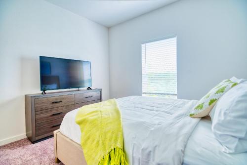 een slaapkamer met een bed en een flatscreen-tv bij Luxe One Bedroom Apartment with Balcony in Gainesville