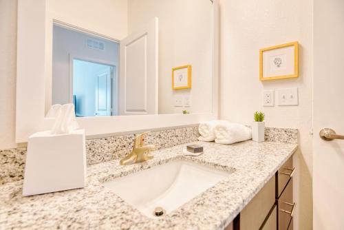 baño con lavabo y espejo grande en Grand Two Bedroom Two Bathroom Apartment with Balcony, en Gainesville