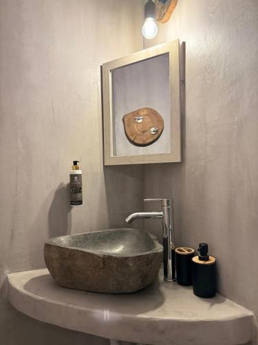a bathroom with a stone sink and a picture at Èlia Luxury Rooms in Areopolis