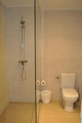 a bathroom with a toilet and a glass shower at Hotel Capri in Port de Pollensa