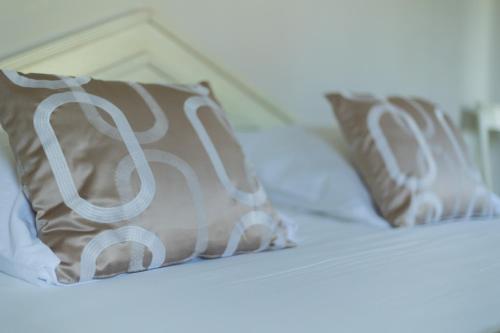 two pillows sitting on top of a bed at Hôtel Méditerranée in Le Lavandou