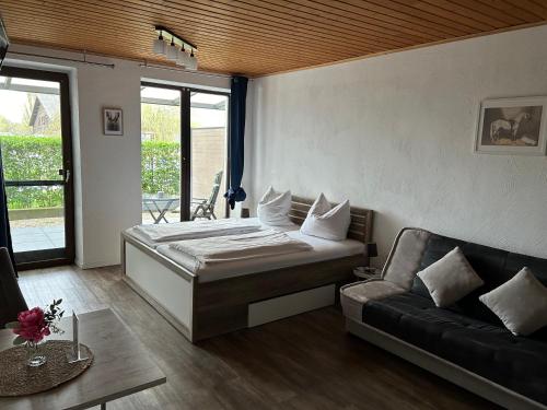 ein Schlafzimmer mit einem großen Bett und einem Sofa in der Unterkunft Ferienwohnung Versteeg am Winkelschen Busch in Kevelaer