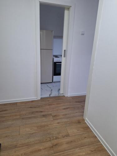 an empty room with a kitchen and a hard wood floor at Relax Lux apartment Nis in Niš