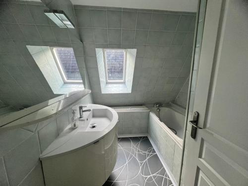 a bathroom with a sink and a tub and a mirror at Le héros - Central - Familial - Spacieux - Parking public proche in Arras