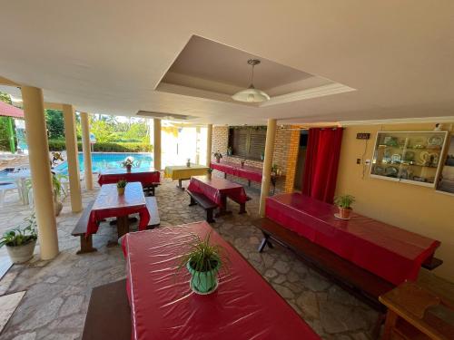 a living room with red furniture and a pool at Pousada Lua Cheia in Japaratinga