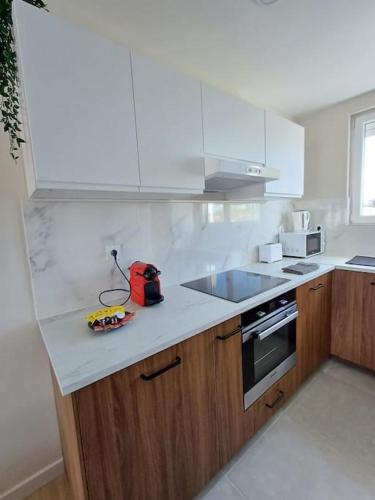 - une cuisine avec un comptoir, un évier et une cuisinière dans l'établissement Le Chopin 6pers 3ch 4 lits wifi, à Agen