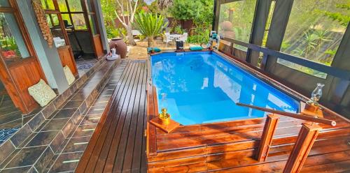 a swimming pool on a house with a wooden deck at Havana Nights in Graskop
