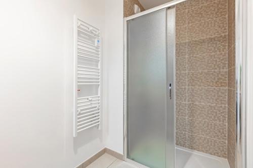 uma cabina de duche ao nível do chão com uma porta de vidro na casa de banho em Fourcats Family em Chennevières-sur-Marne