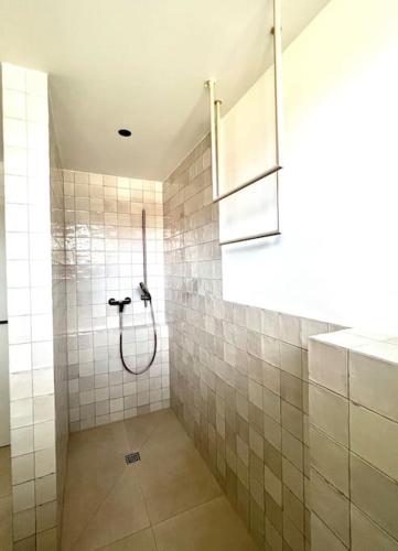 a bathroom with a shower with tiled walls at Luxusappartement hôamele - Ferienwohnung mit Genuss in Alberschwende