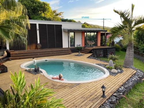a person sitting in a pool in a backyard at L’Oasis Saint Bernard in Saint-Denis