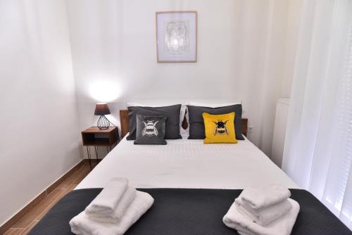 a bedroom with a bed with yellow and black pillows at Antoine Apartment in Néa Péramos