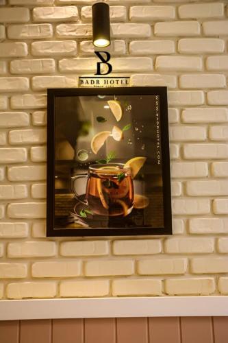 a picture frame hanging on a brick wall with a tea pot at Badr Hotel & Resort El Kharga in Kharga