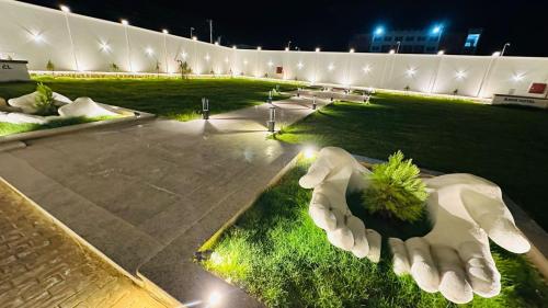 a park at night with a sculpture of a hand at Badr Hotel & Resort El Kharga in Kharga