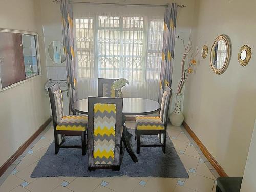 uma sala de jantar com mesa e cadeiras em Homely apartments 4 em Kisumu