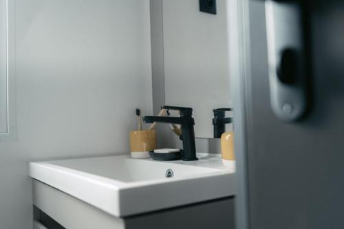 umywalkę w łazience z czarnym kranem w obiekcie Chalet Scharflee w mieście Goebelsmuhle