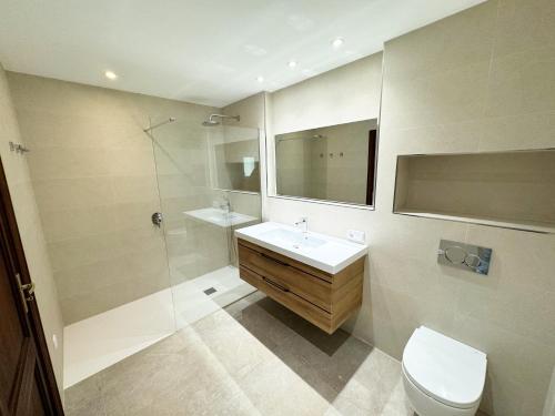 een badkamer met een wastafel, een douche en een toilet bij Maricel in Cala Ratjada