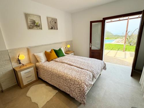 um quarto com uma cama e uma porta de vidro deslizante em Maricel em Cala Ratjada