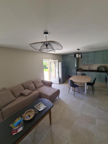 un salon avec un canapé et une table dans l'établissement Gîte chaleureux, à Aunou-le-Faucon