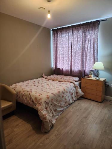 ein Schlafzimmer mit einem Bett, einer Kommode und einem Fenster in der Unterkunft SEYI in Hatch End