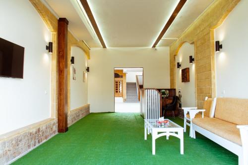 uma sala de estar com um sofá e alcatifa verde em 2Rest em Dahab
