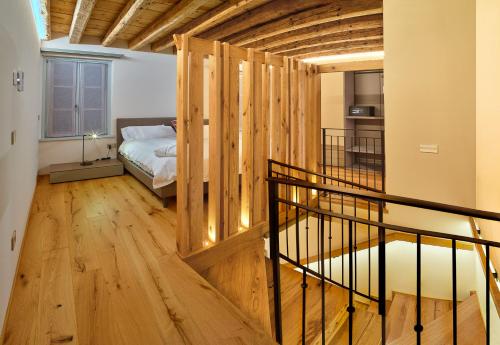una camera con letto e pavimento in legno di PALMANOVA SUITE HOME a Palmanova
