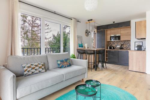 un salon avec un canapé et une cuisine dans l'établissement Fourcats Family, à Chennevières-sur-Marne