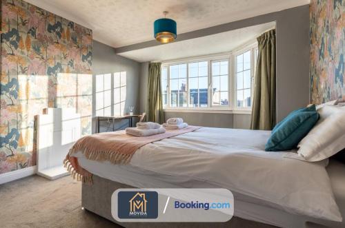 a bedroom with a large bed with a large window at Large Modern 6 Bedroom House By Movida Property Group Short Lets & Serviced Accommodation With Games Room in Adel