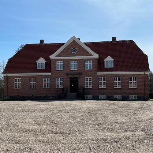 a large red brick house with a large driveway at Sundsgården B&B in Ringe
