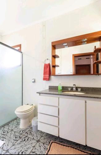 a bathroom with a toilet and a sink at Casa em Cotia in Cotia