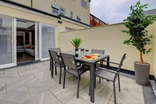 a table and chairs on a patio with a plant at Swish Luxury Holiday Apartments in Blackpool