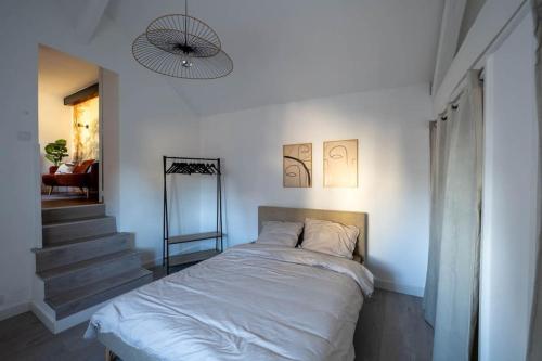een slaapkamer met een bed en een trap met een licht bij Appart COZY proche ORLY/PARIS in Villeneuve-le-Roi