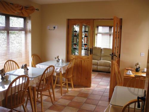a dining room with two tables and a couch at Johnny B's B&B in Ballybofey