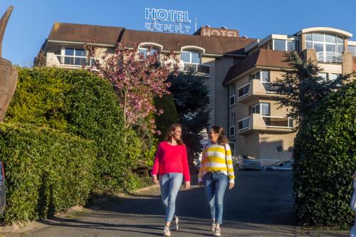 deux femmes marchant dans une rue devant un bâtiment dans l'établissement Hotel Donny, à La Panne