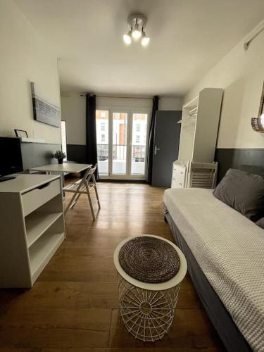 Cette chambre comprend un lit, une table et un bureau. dans l'établissement Cosy studio near beaches, à Nice