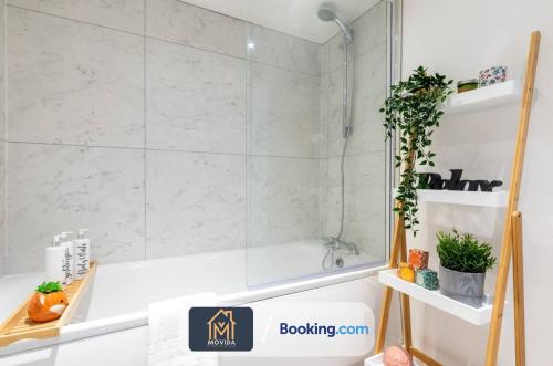 a bathroom with a shower and a tub and a sink at Stylish Two Bed Town Centre Apartment By Movida Property Group Short Lets & Serviced Accommodation With Parking in Harrogate