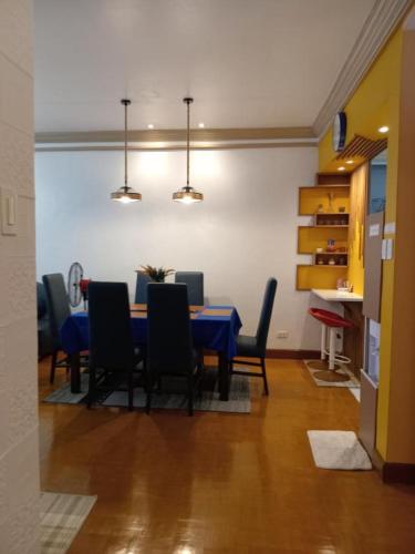 a dining room with a blue table and chairs at De Leon Staycation at Vista de Loro in Ternate