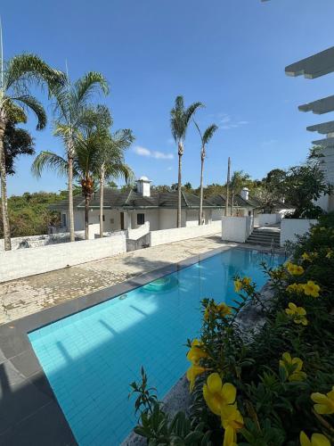 a blue swimming pool with palm trees in the background at De Leon Staycation at Vista de Loro in Ternate
