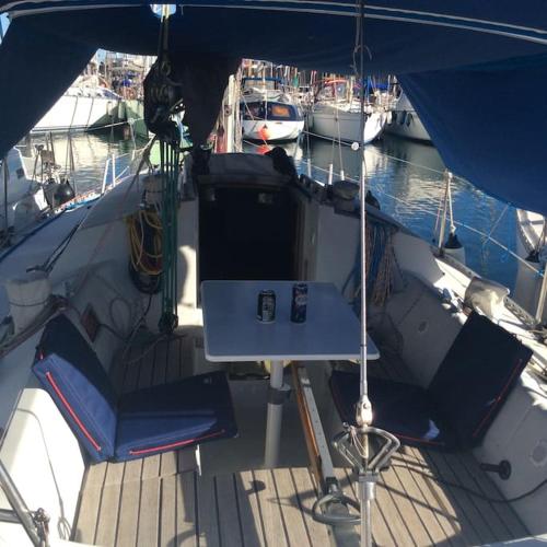 - une table et des chaises sur un bateau dans un port de plaisance dans l'établissement Nuitée à bord de Danilou un voilier de 9.50m, à Sète