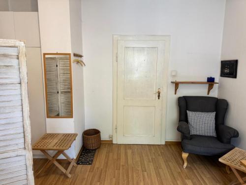 a room with a chair and a door at Gemütliches komfortables Zimmer für 1 Person im Zentrum in Munich