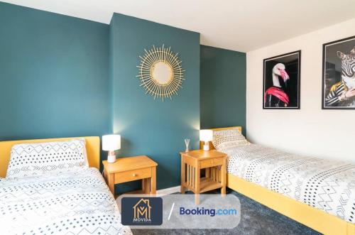 two beds in a room with blue walls at The Hyde Away Chic Urban Two Bedroom House By Movida Property Group Short Lets & Serviced Accommodation in Headingley