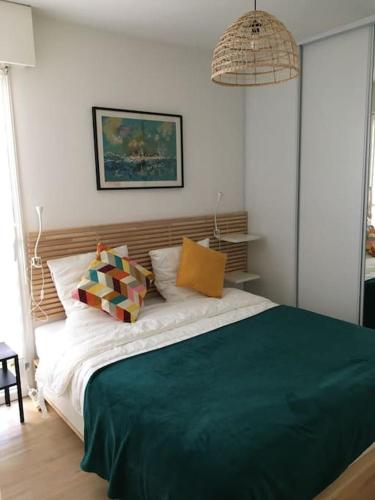 une chambre avec un grand lit avec des oreillers dessus dans l'établissement Appartement lumineux proche du port et de la plage, au Pouliguen